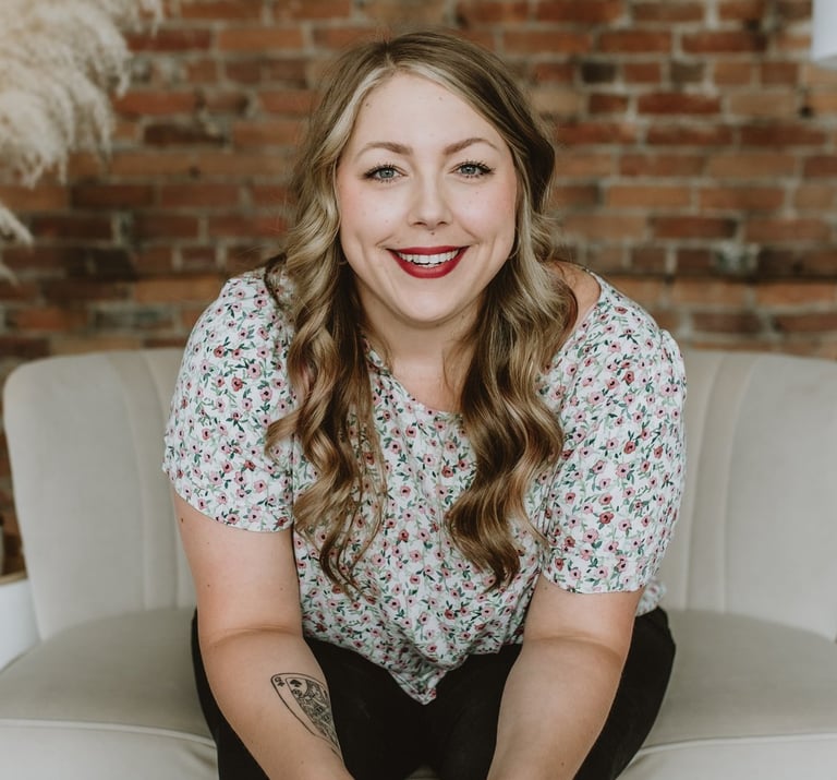 a woman smiling while sitting on a comfy white chair