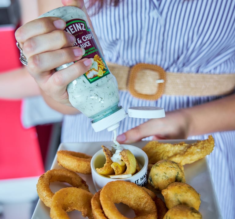 Heinz Fish & Chips Sauce servita con anelli di cipolla, calamari e fritti misti.