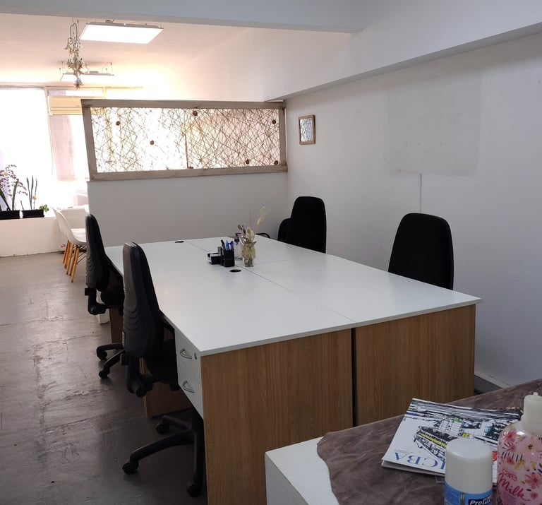 Espacio de trabajo en Red de Llaves con escritorios individuales, silla blanca y luz natural tenue.
