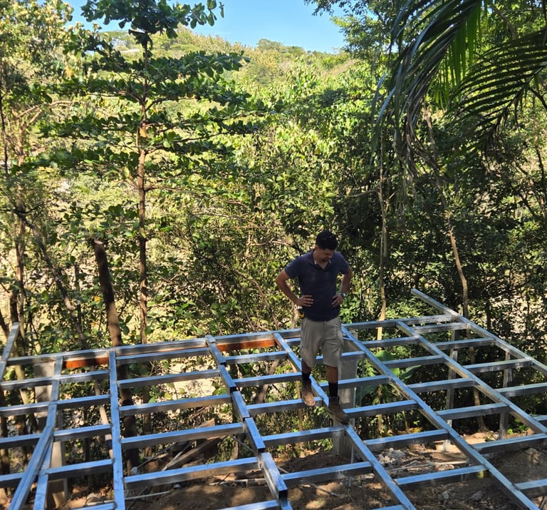 owner of NANCE, Jose Ponce standing on a metal steel structure for base of a house