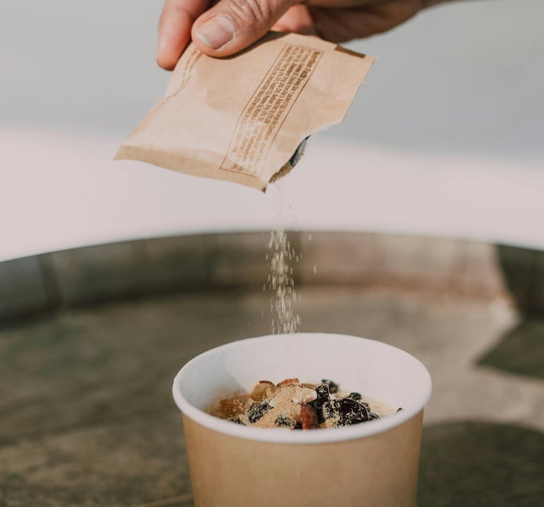 artificial sweetener poured out of packet on fruit dessert