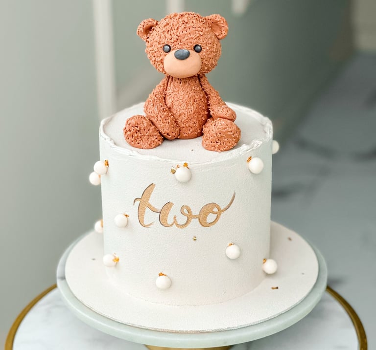 a teddy bear sitting on top of a cake
