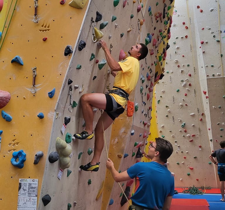 Lead climbing course in Vienna (Marswiese climbing gym, participants belay each other).