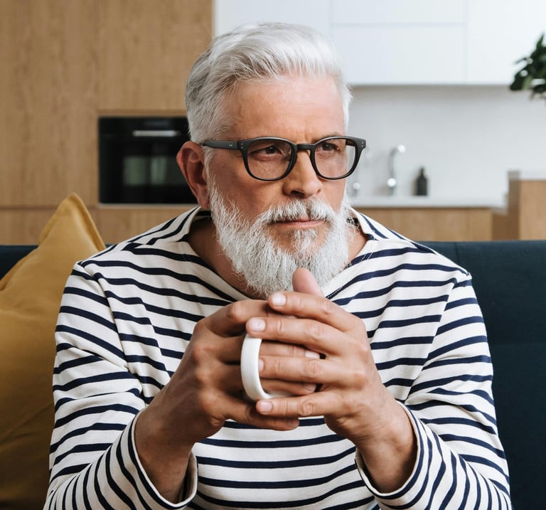 Image of male with glasses and a full head of white hair looking pensive