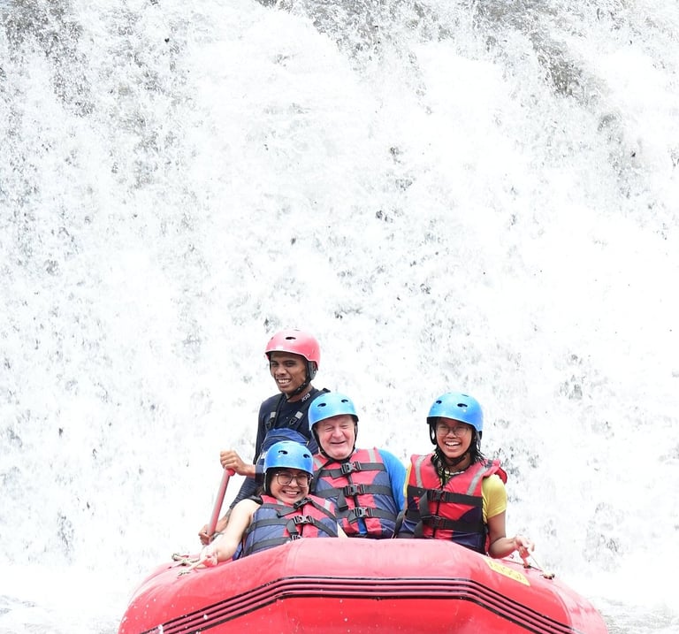 Smiling group wearing helmets and life jackets during a whitewater rafting adventure on a river.