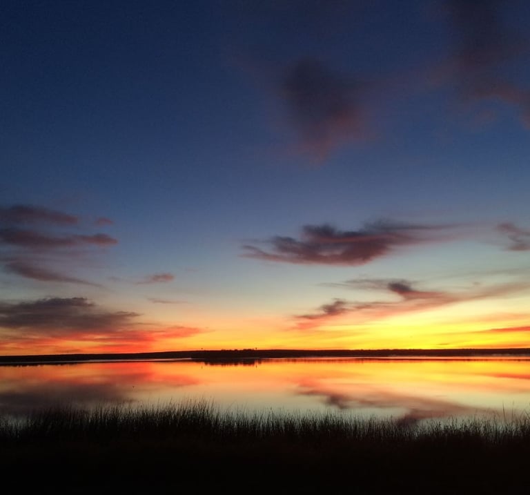 Sunrise colors reflected on a calm lake.
