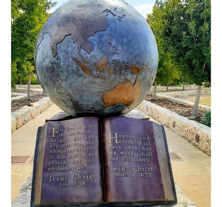 Metal globe sculpture positioned above an open Bible.
