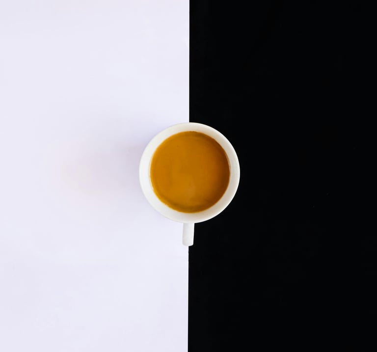 a cup of coffee on top of a white and black table