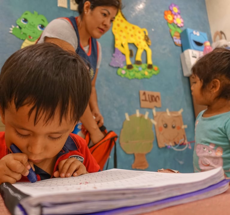 a boy and a girl are sitting at a table at school by Comunidad Nascence