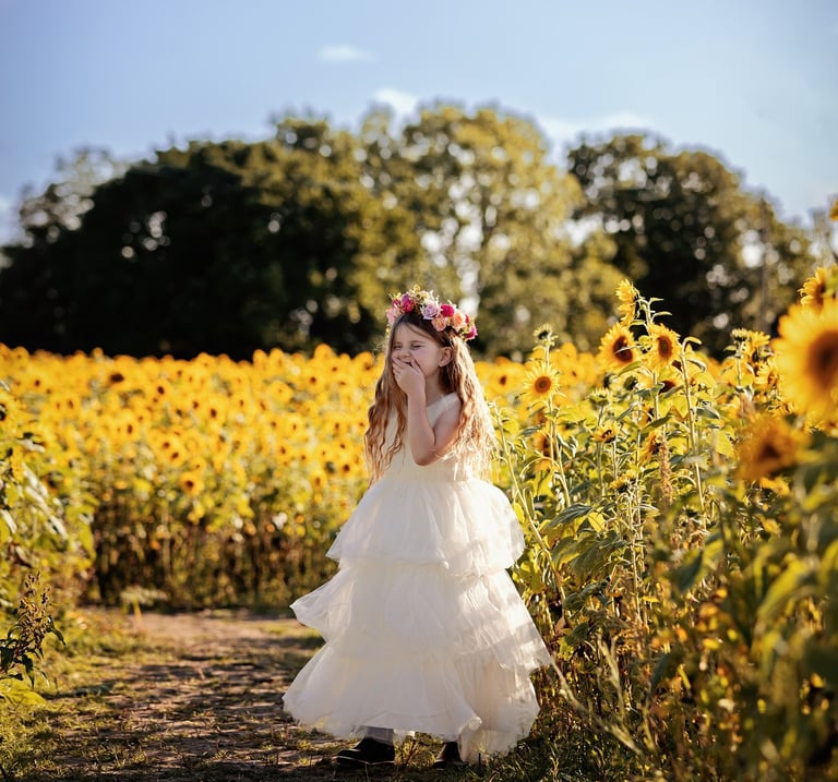 a little girl in a white dress and a flower crown