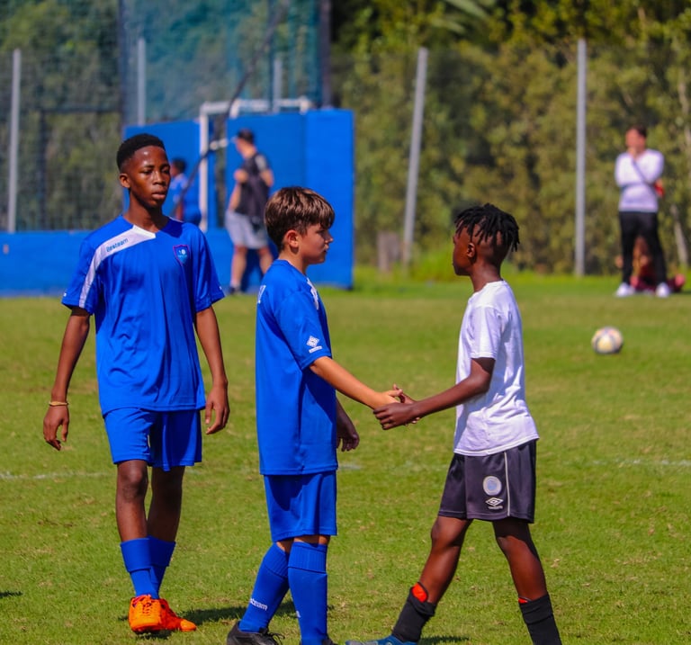 a group of young boys playing soccer on a field