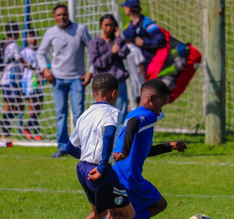 two boys playing soccer on a soccer field