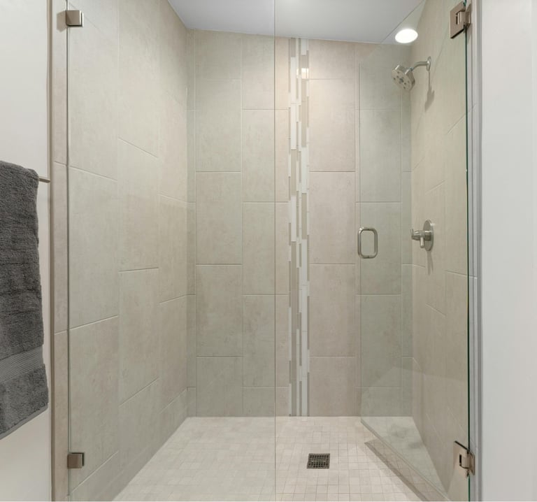 Beige‑tiled frameless glass shower with double doors – typical frameless enclosure repair in Aucklan