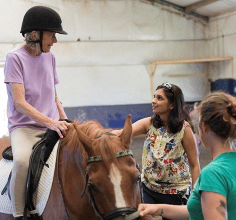 a women with stroke riding a horse