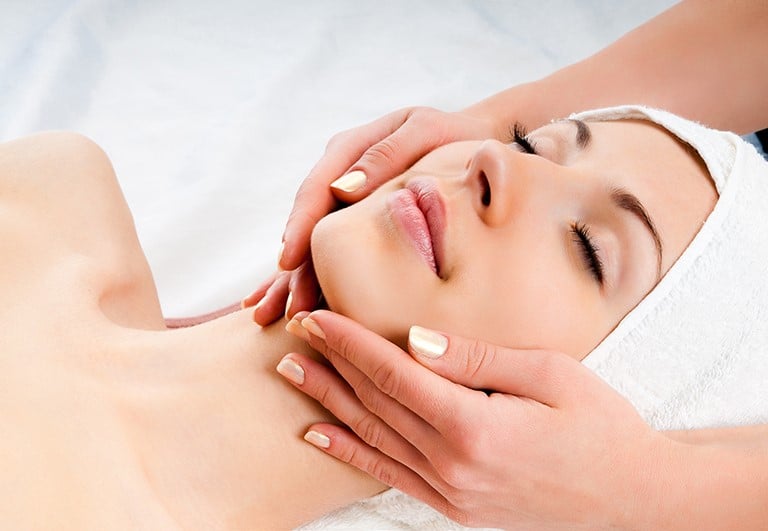 a woman getting a facial massage at a spa