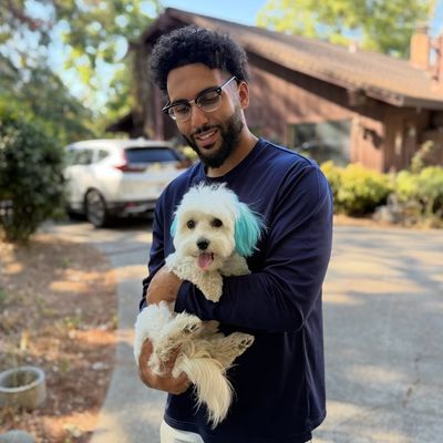 Fahad Aldulaymi holding a puppy at Barkbnb 