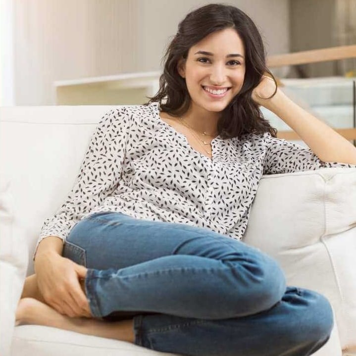 a woman sitting on a couch with her legs crossed