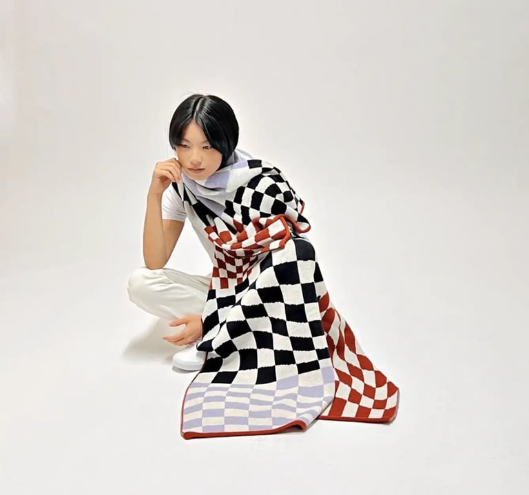 a woman covered by a checkered blanket
