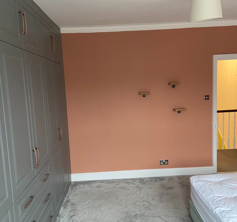 Pink feature wall with fitted wardrobes in Worthing Sussex, professional bedroom painting