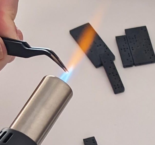 Thermosoudure avec une pince chauffée au chalumeau, utilisé pour fixer des billes d'acier