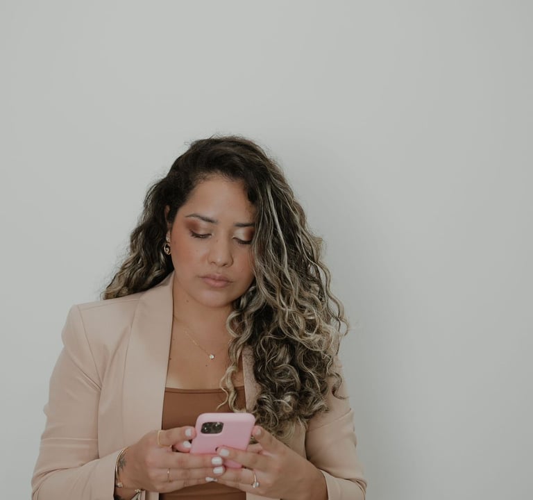 Mulher de Cabelo cacheado de blazer, é a esteticista chamada Janaina Mota