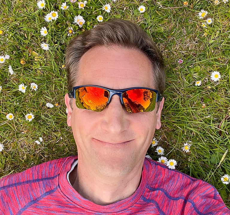 Marcus lying on grass with daisies