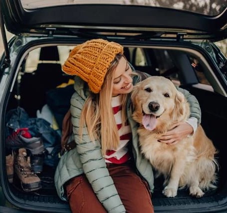 Mujer feliz viajando con su Golden Retriever - Seguro para perros Allianz Murcia