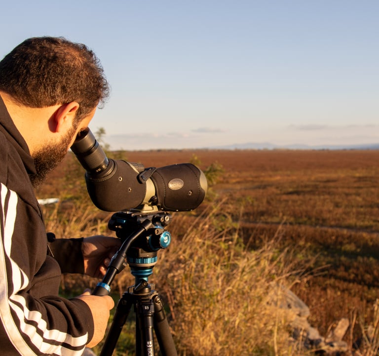a man in a black jacket and a camera on a tripod