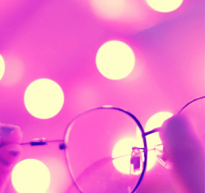 Lunettes sur fond rose et lumineux symbolisant un nouveau regard