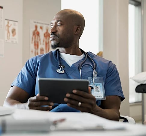 Médico especialista con tablet en consulta - seguro de salud Allianz con atención completa en Murcia