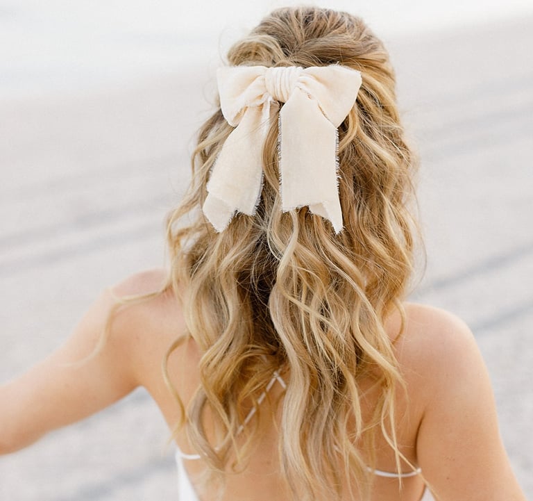 Blonde fashionista bride wears short wedding dress, silk hair bow and natural hair extensions