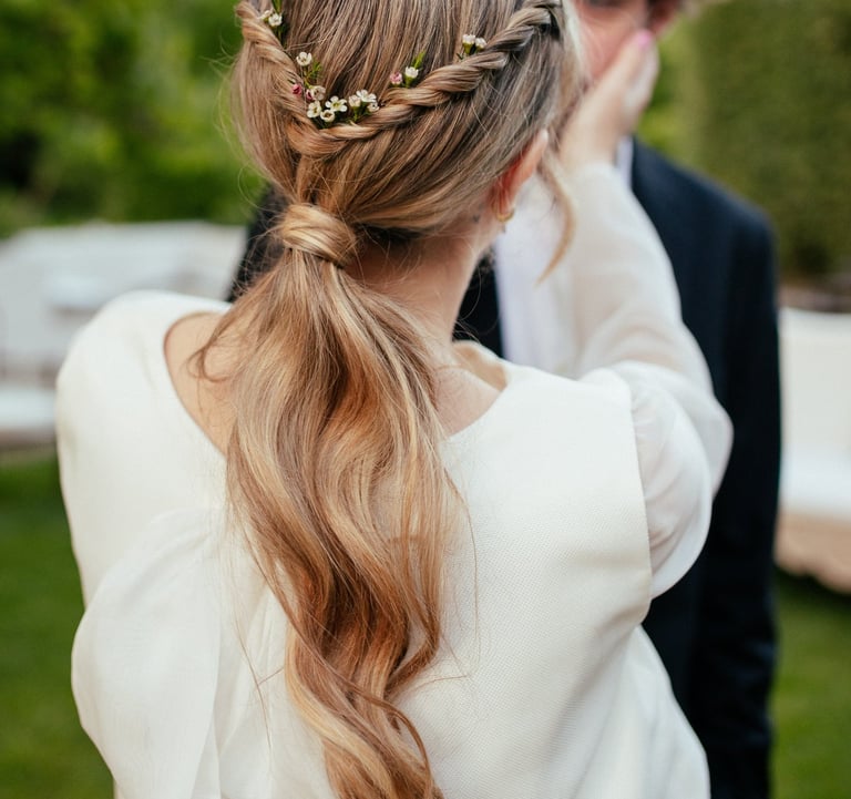Bride with effortless natural ponytail decorated with natural flowers during wedding in Portugal