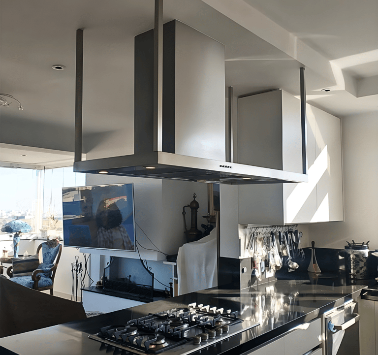 Modern kitchen featuring a stainless steel island range hood over a black granite countertop with a gas stove.