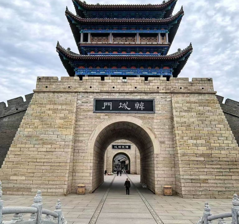 a person walking through a stone wall with a gate