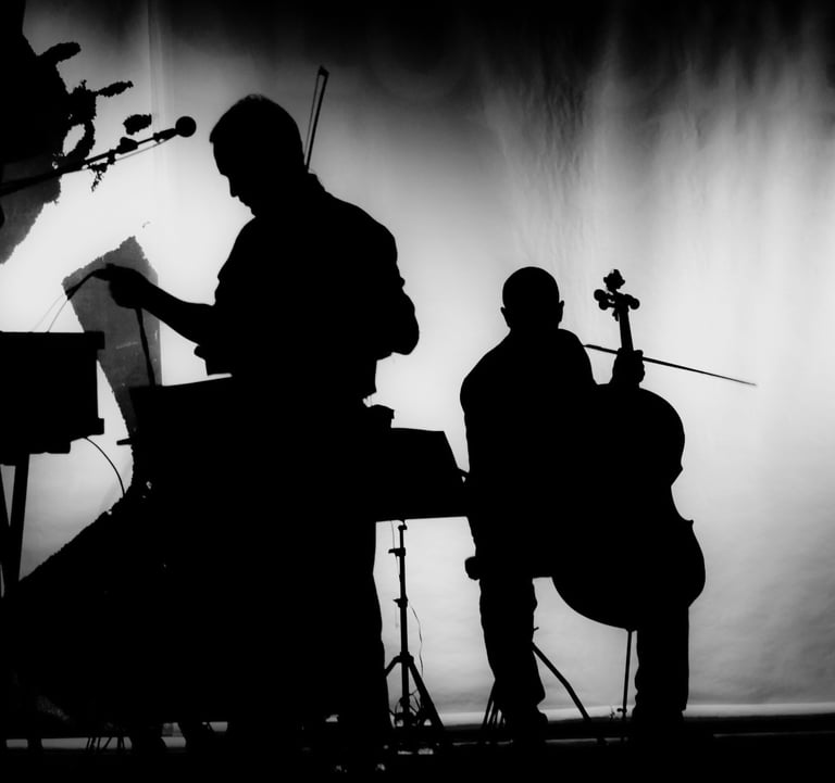 Silhouette of two male musicians, one of them holding a cello.