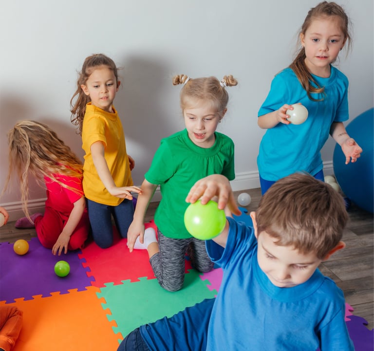 vaikai darzelyje su spalvotais marskineliais
