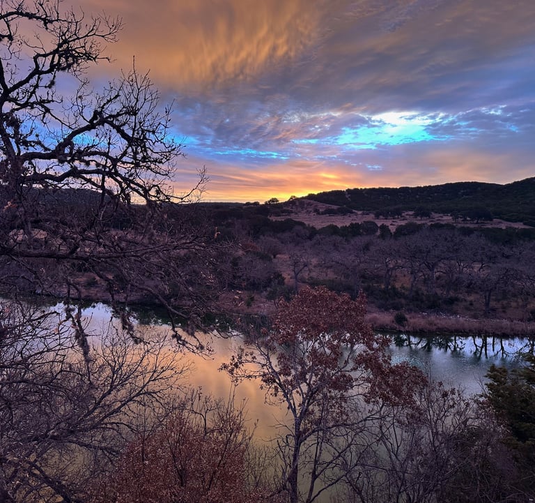 Sunset over river, in mountain terrain.
