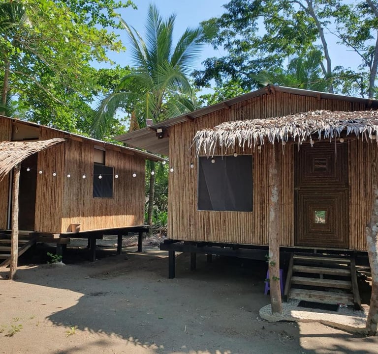 wooden cabins against trees and blue skies on the carribean coast in costa rice at camping babsita