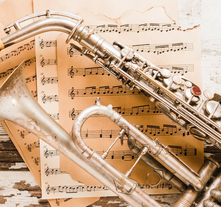 trompette et saxophone posés sur une pile de partitions
