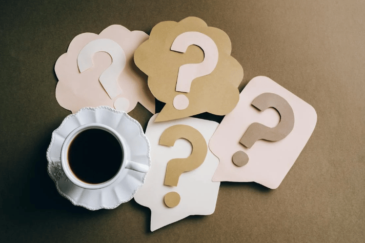 a cup of coffee and question mark mark on a table