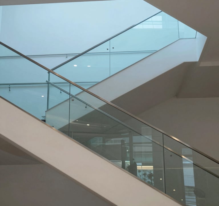 Architectural photography of a modern staircase in a luxury building in Luxembourg. Clean lines, glass railings, and a minimalist aesthetic. The image uses a palette of light blue and off white, conveying a sense of transparency and order.
