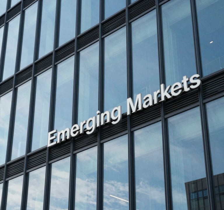 A close-up photograph of architectural glass panels on a modern office building, reflecting a clear sky blue, representing transparency and professional structure in Emerging Markets.