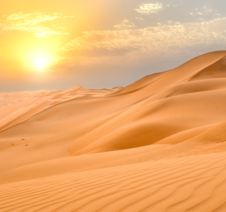 sand dunes in the desert with the sun in the sky