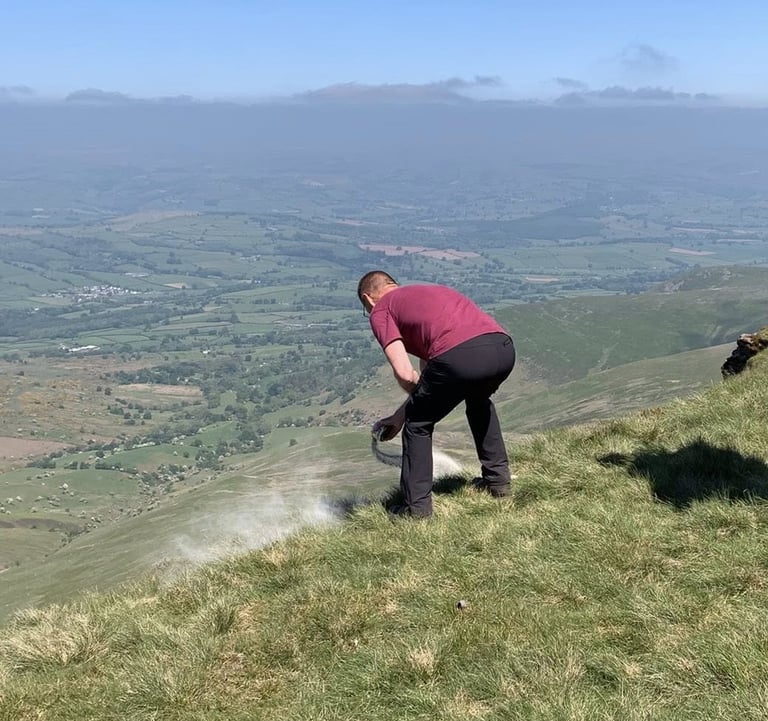 A family member Scattering Ashes, Pen Y Fan, South Wales