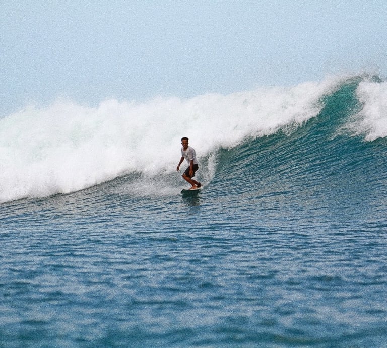 a man riding a surfboard on a wave
