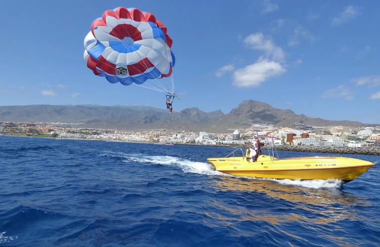 a person parasailing in the water with a parachute