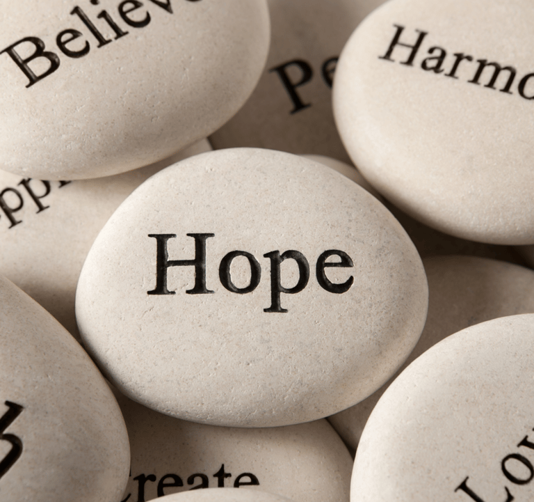 Inspirational rocks with positive words representing motivational books and survival guides