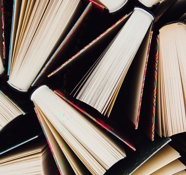 Overhead shot of stacked books representing bold literary work.