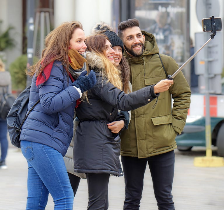 Três mulheres e um homem fazendo uma selfie em uma viagem de turismo