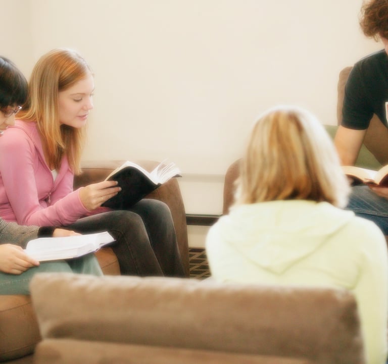 Group of diverse people in living room holding Bibles, sharing enlightenment concepts